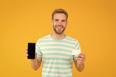 Alışveriş uygulaması ile para biriktir. Mutlu adamın kartı ve telefonu var. Mobil alışveriş aracı. İnternetten alışveriş. Akıllı telefon dükkanı. Alışveriş kartı. Makbuz indirimi ya da kupon. Banka kartıyla alışveriş yapalım, kopyalayalım.