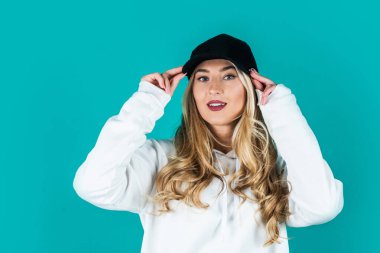 Şapkalı sporcu kız. Hipster tarzı. moda ve güzellik. Seksi kadının uzun sarı kıvırcık saçları var.