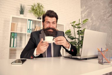 Kahve içerken iş konuşalım. Yakışıklı patron ofiste oturup kahve içiyor. Rahat çalışma alanı. İyi sabahlar. Sakallı hippi kıyafeti kahveyle rahatlıyor. Ofis hayatı rutinleri. Saygıdeğer CEO.