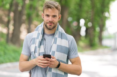 Aktif yaşam tarzın için telefon. Fit adam cep telefonundan müzik dinliyor. Antrenman ve spor eğitimi için telefon uygulamaları kullanıyorum. Modern hayat. Yeni teknoloji. Forma girmek için telefonunu kullan.