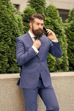 Bağlantıda kalın. İş adamı cep telefonundan konuşur. Dışarıda cep telefonu olan yakışıklı sakallı adam. Taşınabilir yaşam tarzı. İş iletişimi. Mobil teknoloji. İş görüşmesi. Şık adam smokin giyer.