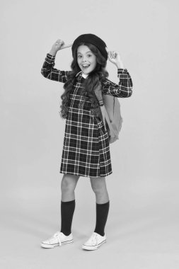 Yeni tarzım. Eğitim konsepti. Okul ve moda. Öğrenci üniformalı çocuk. Sarı arka planda Fransız bereli bir çocuk. Şık bir genç üniversite öğrencisi. Sırt çantalı küçük kız okula gidiyor.