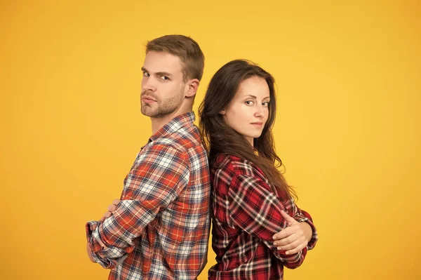 Adult siblings. Sister and brother. Confident team. Back to back standing man and woman. Fashion clothes shop. Modern couple. Couple checkered shirts. Family look. People concept. Family relations