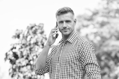 Telefon için beklemedeyim. Yakışıklı bir adam dışarıyı arıyor. Cevap ver. Gelen arama. Telefon görüşmesi. Mobil iletişim. Yeni teknoloji. Modern hayat