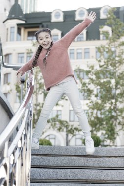 Merdivenlerden iniyorum. Mutlu enerjik çocuk sıradan kıyafetlerle basamaklarda zıplıyor. Hareketli uzun saç örgüleri olan enerjik küçük bir kız. Havada gülümseyen enerjik küçük bir çocuk. Etkin ve enerjik