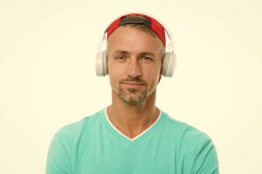 Şapkalı adam müzik kulaklığı dinliyor. Keyfin yerinde. Modern kablosuz kulaklık. Mükemmel bir fikir. Elektronik dans müziği ve ev şarkıları. Enstrümantal müzik. Erkek kulaklıkları beyaz arkaplan