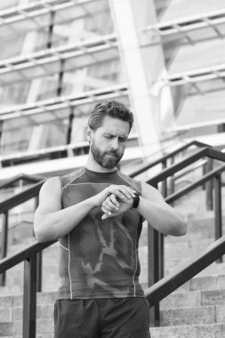 Sağlıklı yaşam ve kendini kontrol kavramı. Fitness hedeflerine ulaşmak için. Dostum, nöbet zamanı. Adam yarıştan önce GPS saatini ayarlıyor. Egzersiz sırasında sağlık kontrolü teknolojisi kavramı