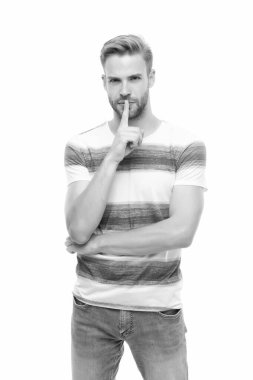 Yüzü kıllı seksi bir adam şık bir yaz gömleği giyiyor. Beyaz arka planda izole edilmiş sessiz bir jest yapıyor. Sessizlik kavramı.