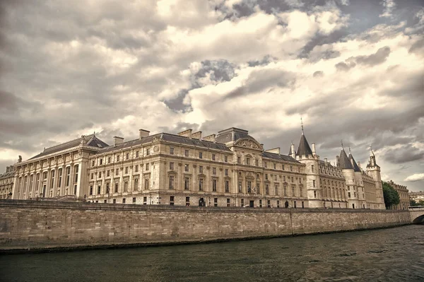 Place of interest. Palace at embankment. Palace building river view. Old palace in paris france. Palace residence on cloudy sky. Architecture and structure. Historical monument. Travel destination