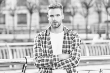 Çapraz elli yakışıklı, kareli gömlek giyen, şık saç stili, erkek modası ve berber dükkanı olan bir adam.