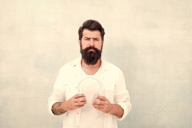 Sakallı adam kulaklıkları arka planda. Hippi müzik kulaklığı dinler. Modern kablosuz kulaklık. Mükemmel bir fikir. Elektronik dans müziği ve ev şarkıları. Enstrümantal müzik