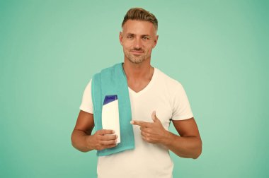 Şampuanlı yakışıklı adam. Jöle şişesi sunan adam. Erkek güzellik ve sağlık. Günlük sabah rutini. Tıraşsız bir adamın şık saçı ya da saç kesimi vardır. Havluyla duş almaya hazır mısın?