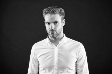 Tıraşsız yüz kılları, şık saç kesimi, gri arka planı ve kuaförü olan yakışıklı beyaz bir adam.