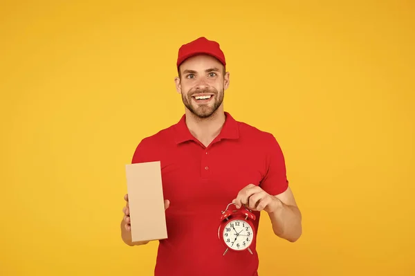 Delivery time. Delivery Courier with time clock holding box. take your parcel. gift delivery man holding vintage clock. go online shopping. Delivery during quarantine. friendly staff man — Stock Photo, Image