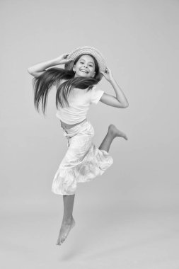 Neşeli küçük kız yaz kıyafetleri atlama, enerji ve hareket konsepti