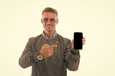 Bu telefonu beğendin mi? İşadamı cep telefonunu işaret ediyor. Yakışıklı adam telefonu beyazda izole etmiş. İş iletişimi. 3G mi? 4G mi? Mobil cihaz. Cep telefonuyla asla yalnız kalmazsın.