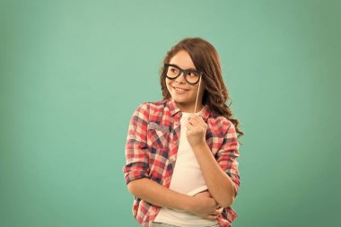 İnek partisi. Şirin inek. Akıllı bebek. Gözlüklü çocuk, sevimli fotoğraf kabini aksesuarları tutuyor. Çocuk büyüsü turkuaz bir geçmişi var. Kız parti için gözlük tutuyor. Gözlüklü çocuk kopyalama alanı