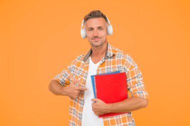 İngilizce öğreniyorum. Eğitim teknolojisi. Çalış. Ses kitabı konsepti. Dünya çapında bilgi erişimi. Ses kütüphanesi. Başka bir çalışma şekli. Yakışıklı üniversite öğrencisi kulaklıkları. Dil çalış