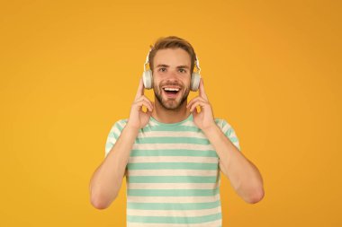 İşte ben buna müzik derim. Mutlu adam sarı arka planda müzik dinliyor. Yakışıklı adam kulaklıkla müzik çalmaktan hoşlanıyor. Modern hayat. Yeni teknoloji. Eğlence ve eğlence. Müzikte kaybolmuş