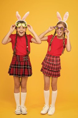Biz en iyi arkadaşlarız. Komik küçük kardeş çocuklar Paskalya partisini kutluyor. Geleneksel bahar tatili. Mutlu Paskalyalar. Bahar geldi. Mutlu çocukluk kavramı. Küçük kızlar tavşan kulakları sarı arka plan