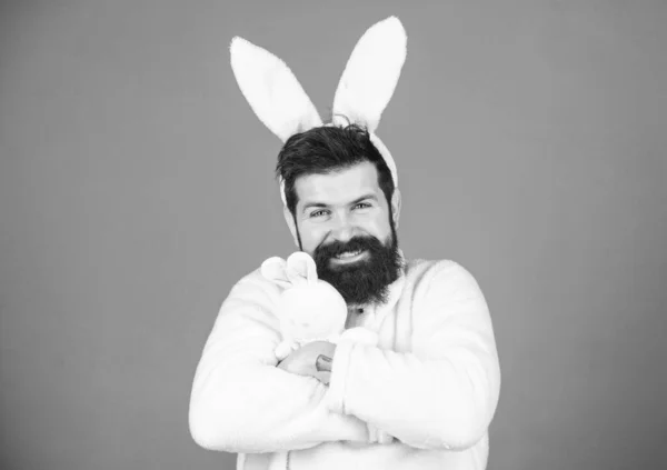 Childhood memories. Man handsome face wear white bunny ears. Easter bunny. White bunny symbol of easter holiday. Soft and tender. Guy with bunny or rabbit ears on violet background. Enjoy tenderness