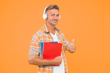 Başka bir çalışma şekli. İngilizce öğreniyorum. Eğitim teknolojisi. Çalış. Ses kitabı konsepti. Dünya çapında bilgi erişimi. Ses kütüphanesi. Yakışıklı üniversite öğrencisi kulaklıkları. Dil çalış