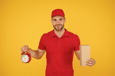 Nakliye servisi. Postane. İnternetten alışveriş. Kararlaştırılan zamanda teslim edilecek. Zamanlama garantisi. Dakiklik ve dakiklik. Teslimat zamanı. Saati olan bir kurye. Teslimatçı saat tutuyor.