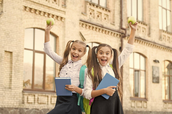 маленький ученик с блокнотом и яблоком. Обед на школьном перерыве. счастливые дети в форме. изучение предмета вместе. современное образование для девочек. чтение книг. концепция дружбы. Пора есть.