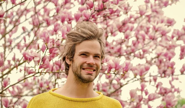 Joy of spring. Man flowers background. Spring beauty. Hipster enjoy blossom. Springtime concept. Guy relax in flowers park. Botanical garden. Freshness and awakening. Spring inspiration. April may