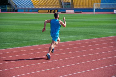 Hedef ve başarı. Stadyumda koşan bir adam. Spor ve sağlıklı yaşam tarzı rutini. Spor antrenmanı. Sporcu sabah egzersizi yapar. Sporcu koşucu dışarıda. Sağlık hizmeti. Enerji. Kaslı adam başarıya koşar