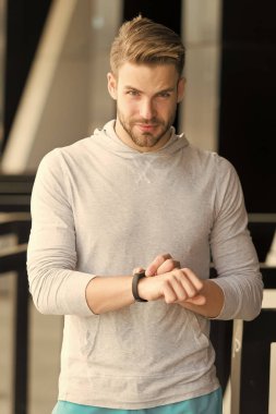 Spor izleme arenasına hücresel bağlantı getir. Atletik adam, spor saatini kontrol et. Sporda yakışıklı adam açık havada giyiniyor. Kalp atışı eğitimi. GPS izleme. Düzenli antrenman. Etkin yaşam tarzını izle