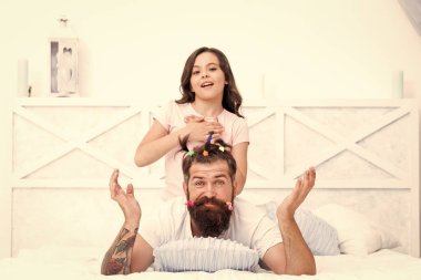 Boş zaman. Birliktelik. Evde birlikte vakit geçirmek. Küçük kız babası için komik bir saç stili yapmış. Kızım ve babam birlikte oynuyorlar. Gelecekteki kariyerinin kuaförü. Baba çocukla eğleniyor.