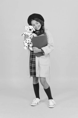 Küçük kız okulda oyuncak köpekle oynuyor, çocuklukta.