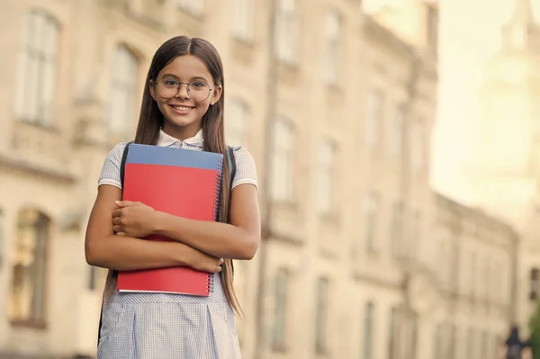 Feliz niño pequeño usar gafas y vestido de escuela celebración de libros de estudio al aire libre, educación, espacio de copia — Foto de Stock