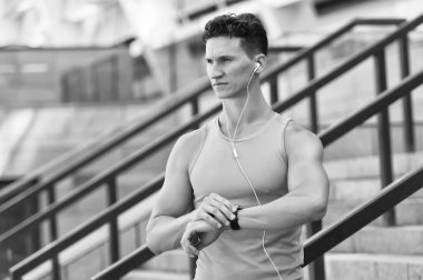 Eğitim ve yaşam tarzı konsepti. Kalp atış hızı olan bir koşucu spor akıllı saatini izliyor. Saate bakıyorum. Spor salonunun dışında sıkı antrenman. Bilek temelli kalp atış hızı monitörü. Çalıştırılan zamanı kontrol ediyorum