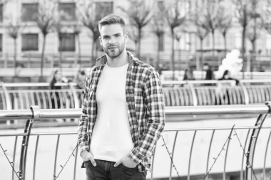 Kendi tarzında. Tıraşsız, kıllı, şehir tarzı bir adam. Modern yaşam konsepti. Öğrenci yürüyüşü. Yakışıklı genç adam kareli gömlek giyiyor. Sıradan giyinmiş erkek manken dışarıda poz veriyor.