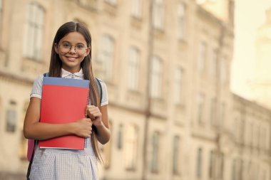 Başarılı olmak için okumalısın. Mutlu çocuk kitapları tutuyor. Okul kütüphanesi. Kütüphane okuyucusu dışarıda gülümser. Okuma ve okur yazarlık eğitimi. Bibliotheca. Şirin kitap kurdu gözlük takıyor. Okula geri dön, kopyalama alanı