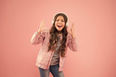 En iyi sonbahar vuruşu. Ses sesi. Eğlence ve eğlence. Müzik açık. Mutlu çocuk müzik dinlemekten zevk alır. Küçük kız pembe kulaklık takıyor. Ses titreşimleri. Müzik ve teknoloji