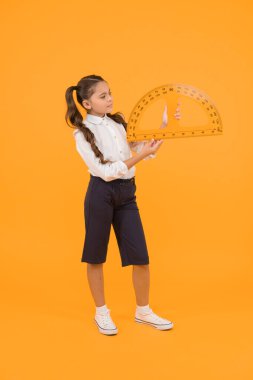 İletki ile kare ayarlanıyor. Küçük kız sarı arkaplandaki açıları ölçmek için üçgen kullanıyor. Geometri dersi için okul ekstraktörü tutan küçük bir çocuk. İleti iletkeni kullanmayı öğrenme