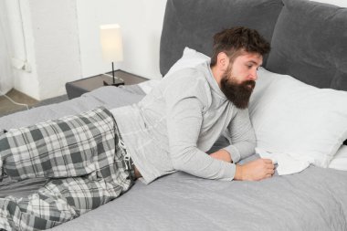 Uyanmak zor. Sakallı hippi adam sabah uyumak istiyor. vahşi uykucu adam yatak odasında. Yatakta pijamalı, sakallı olgun bir erkek. Uyuyor ve uyanık. Enerji ve yorgunluk. Bugün uyanma.