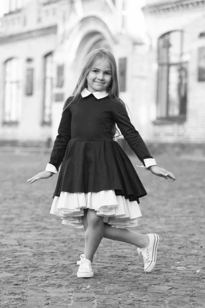 Dance etiquette. Happy child make curtsy outdoors. Small dancer wear school uniform. Back to school fashion. Dance education. Let your feet do the talking