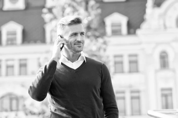 Call partner. Mobile negotiations. Business communication. Online communication. Modern communication. Businessman hold mobile phone. Handsome man with phone outdoors. Mobile lifestyle. Listening