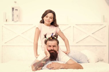 Coronavirus karantinası ve çocuğuyla evde mahsur kalan babam. Aile eğlencesi. Pijama partisi. Mutlu bir çocukluk. Yatak odasında dinleniyor. Baba için saç yapan bir kız. Çocuklarla karantina. Mutlu aile