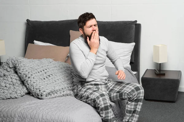 Levántate temprano. Consejos para levantarse temprano. Hombre barbudo hipster soñoliento pijama de la cara despertar dormitorio interior. Horario diario para un estilo de vida saludable. Descansa y relájate. Problema con el despertar temprano en la mañana —  Fotos de Stock