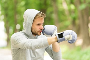 Saldırı ya da savunma her zaman hazır olsun. Sporcu konsantre boks eldivenleri. Sporcu odaklı yüz sporu eldivenleri dövüş becerileri doğa arka planı. Yakışıklı boksör.