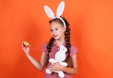 Tavşan kız Paskalya tavşanı oyuncağını yumurta avı ve paskalya yumurtası için hazır tut.