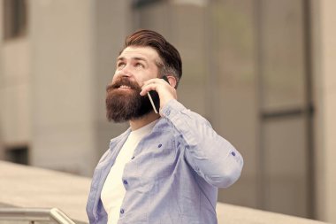 Açık havada kıllı yakışıklı bir adam. Mobil iletişim. İş görüşmesi. Akıllı telefonu olan bir adam. Sıradan gömlek giyen bir adam akıllı telefonu tutar. Modern hayat. Çevik iş. Teşekkür ederim. Nasıl gidiyor?