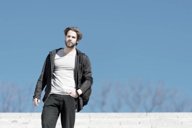 Mavi gökyüzünde maço duruşu, perspektif. Güneşli açık havada sakallı bir adam, moda. Bakış açısı, gelecek, özgürlük. Erkek modası ve tarzı, kopyalama alanı