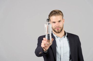 Gri arka planda plastik şişesi olan adam, susamış.