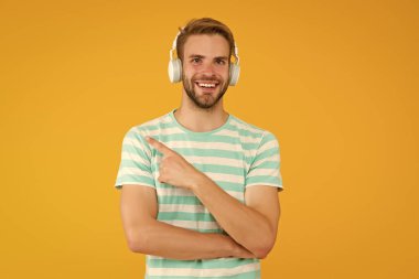 Müzik üretimi için ürün. Mutlu adam işaret parmağı sarı arka plan. Ürün tanıtımı. Ürün reklamı. Ses teknolojisi. Müzik teknolojisi ürünleri yaratıcılığınıza ilham verecek, alanı kopyalayacak.